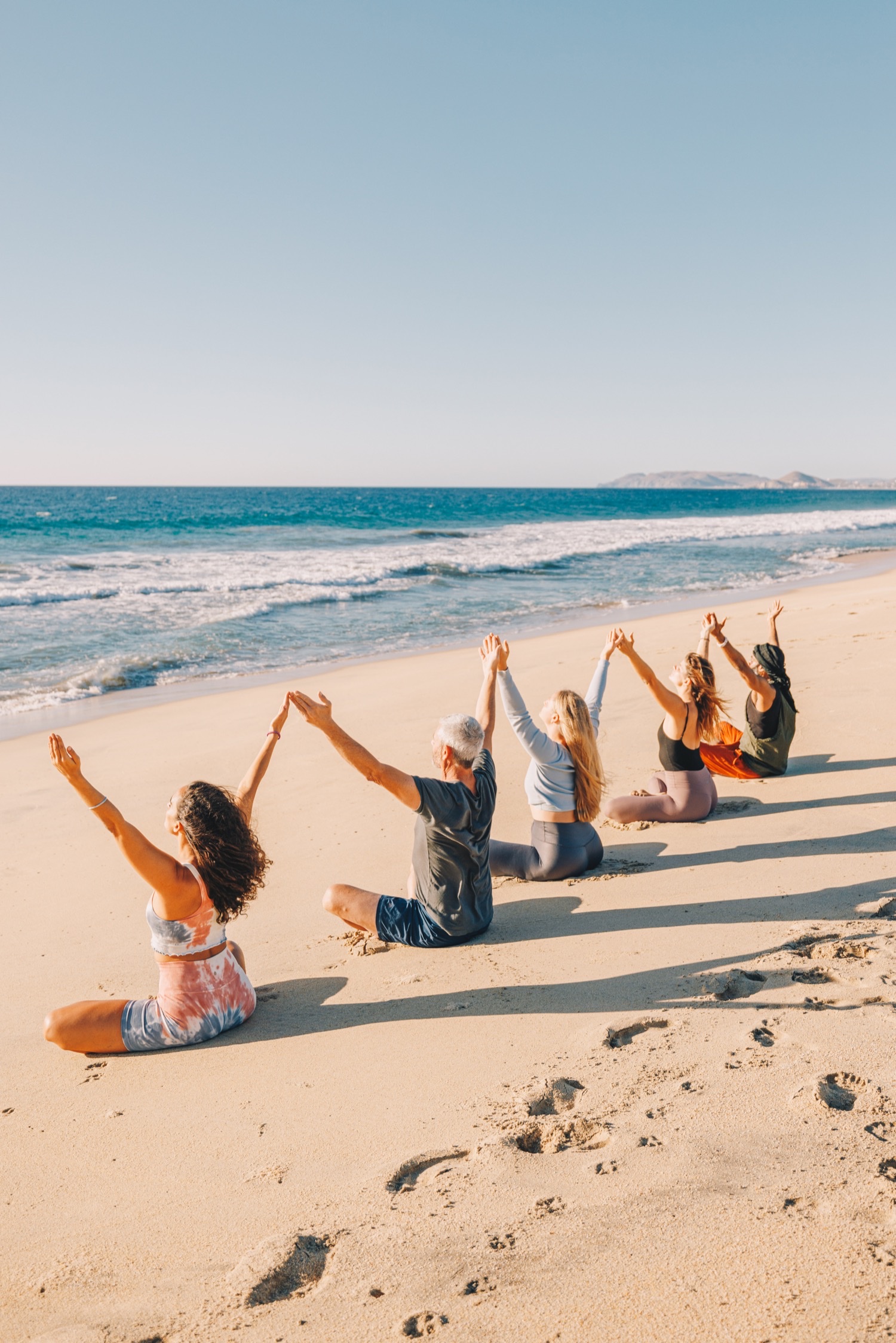 People on the beach with hands in the air